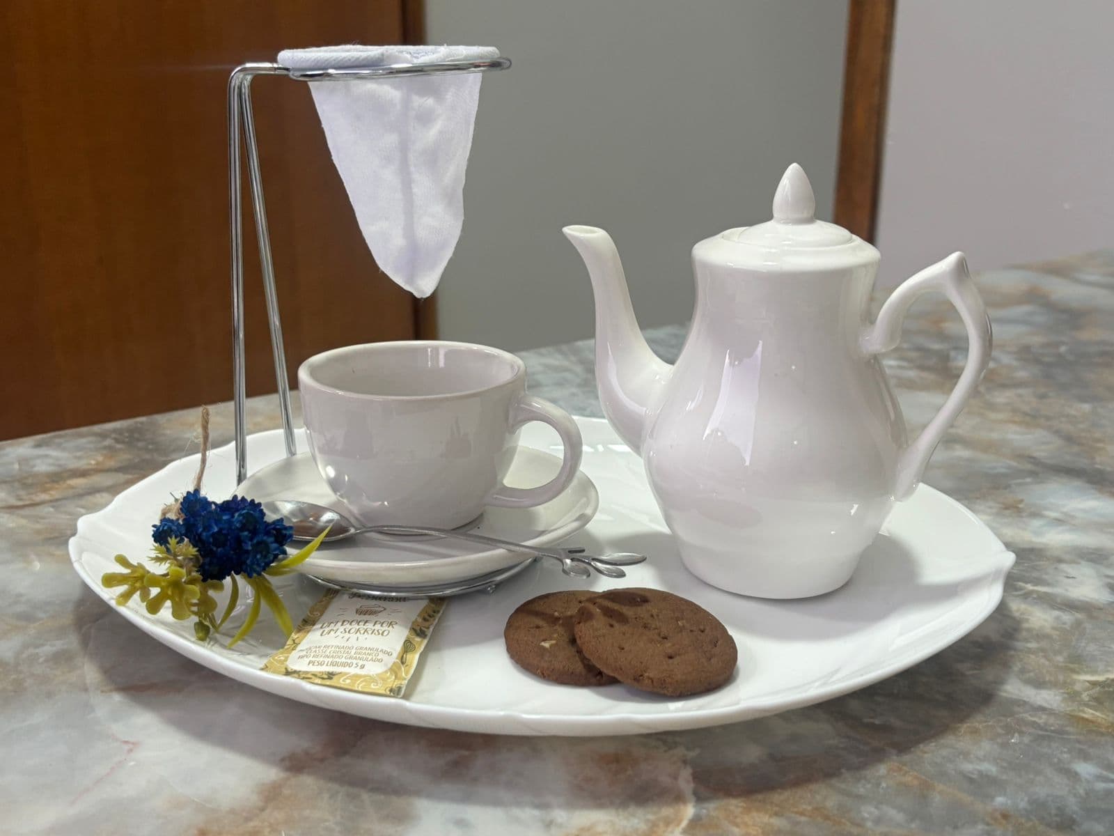 Cantinho do café da recepção da Sencis, com bule, xícara e biscoitos
